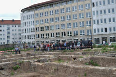 Interessierte Teilnehmer an der Führung warten vor dem Eingang zum Grabungsgebiet